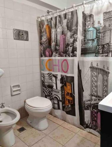 a bathroom with a toilet and a shower curtain at Lindo departamento pleno centro. in San Fernando del Valle de Catamarca