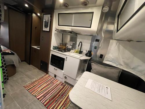 - Cocina con fregadero y mesa en Airstream Caravel 2020 Loblolly Pines Adventure Camp en Eureka Springs