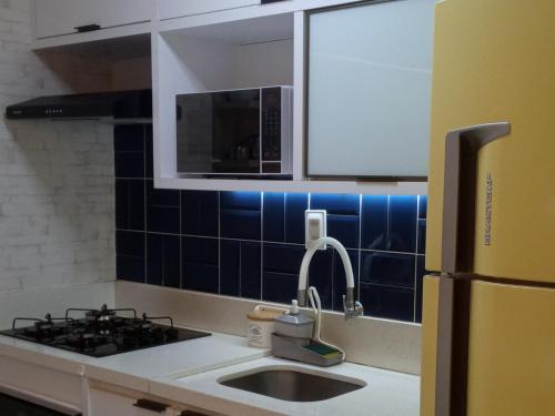 a kitchen with a sink and a refrigerator at Apartamento Estilo Prime in Salvador