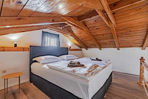 un grande letto in una camera con soffitti in legno di Seaside house for families with children Postup, Peljesac - 20849 a Orebić (Sabbioncello)