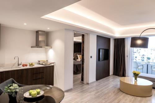 a kitchen and a living room with a table at Almond Business Hotel in Nicosia