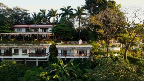 a house in the middle of a garden with trees at Tierra Magnifica Boutique Hotel in Nosara