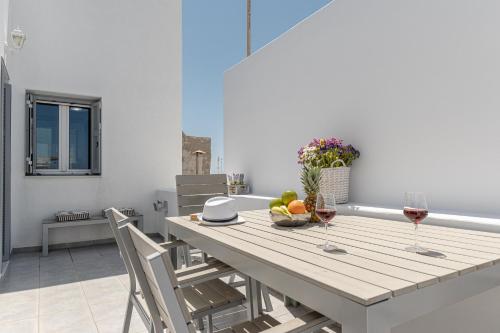 ナクソス・コラにあるVilla Nektar, Luxury Apartment in Chora Naxosのワイン2杯とフルーツ1杯付きのテーブル