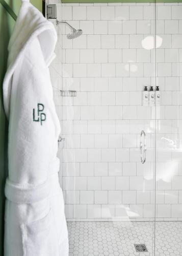 a bathroom with a shower with a white towel at Le Petit Pali at 8th Ave in Carmel