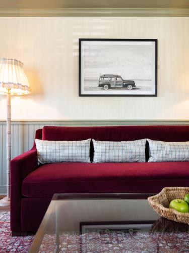 a living room with a red couch and a picture of a car at Le Petit Pali at 8th Ave in Carmel