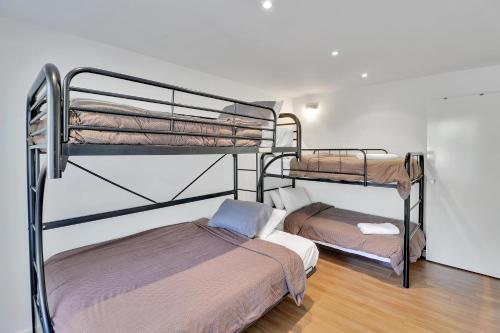 two bunk beds in a small room with a bed at Ren Basera in Mount Buller