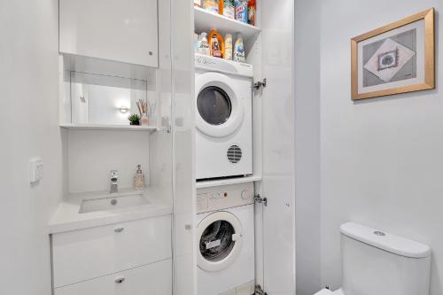 a white bathroom with a washer and dryer in it at Ren Basera in Mount Buller