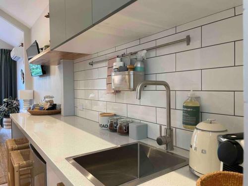 a kitchen with a sink and a counter top at Stylish Geelong Cabin - Your home away from home in Belmont