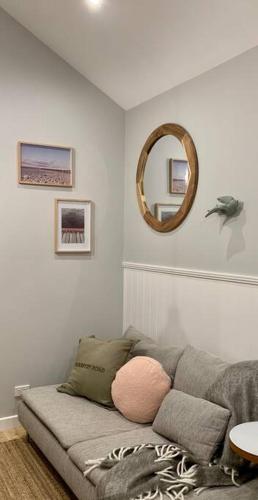 a living room with a couch and a mirror at Stylish Geelong Cabin - Your home away from home in Belmont