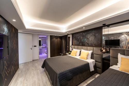 a hotel room with two beds and a television at Almond Business Hotel in Nicosia