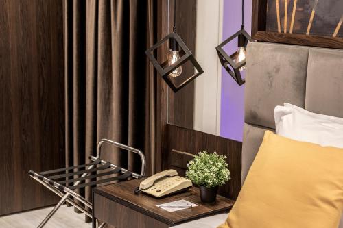 a hotel room with a bed and a phone on a table at Almond Business Hotel in Nicosia