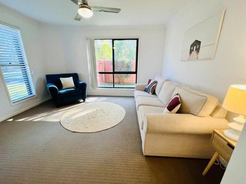 a living room with a couch and a chair at Sandstone Point Sleeps 10, 4-bedroom home in Sandstone Point