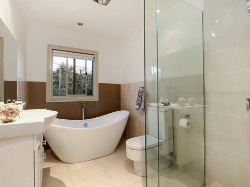 a bathroom with a tub and a toilet and a shower at Glenvale in Sorrento