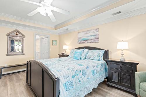 a bedroom with a bed and a ceiling fan at Brass Rail 119 in Tybee Island