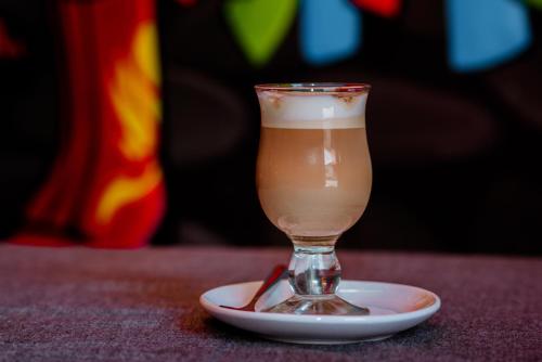 einen Drink in einem Glas auf einem Teller auf einem Tisch in der Unterkunft Huanuco Pampa Suite in Huánuco