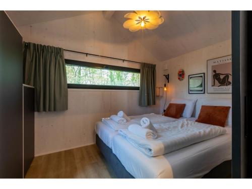 a bedroom with two beds with white sheets and a window at Tiny House Zoutelande near the Beach in Zoutelande