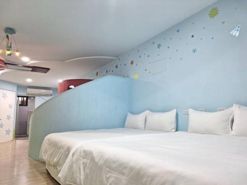 1 dormitorio con 1 cama grande y pared azul en 拾光悠宿, en Yuli