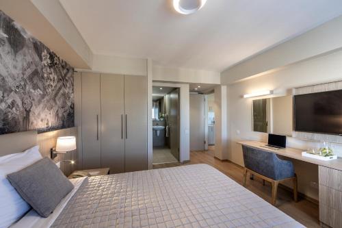 a bedroom with a bed and a desk and a television at Almond Business Hotel in Nicosia