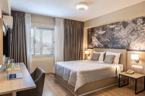 a hotel room with a bed and a desk at Almond Business Hotel in Nicosia