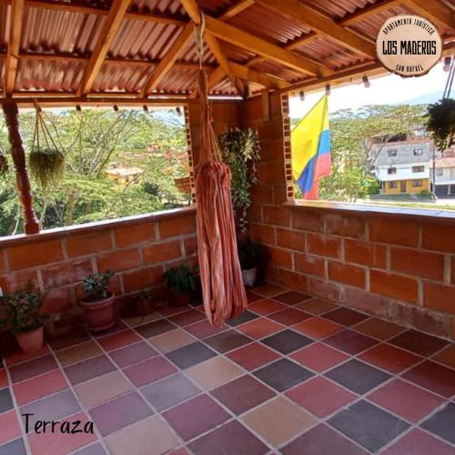 a room with a tile floor and a window with a flag at Los Maderos San Rafael Antioquia Apartamento Turístico in San Rafael