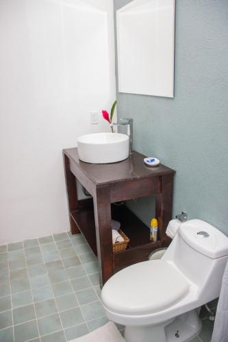 a bathroom with a white sink and a toilet at Chango's Apartments in Bocas del Toro