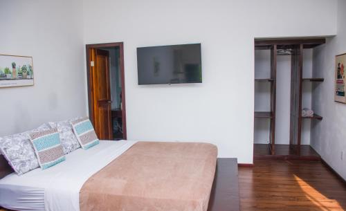 a bedroom with a bed with a tv on the wall at Chango's Apartments in Bocas del Toro