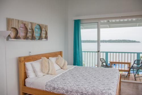 a bedroom with a bed with a view of a balcony at Chango's Apartments in Bocas del Toro