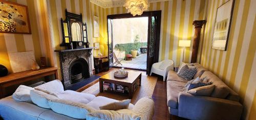 - un salon avec deux canapés et une cheminée dans l'établissement Grand Terrace With Secret Garden - 4 Bedrooms, à Sydney