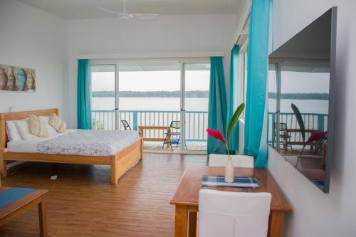 Schlafzimmer mit einem Bett und einem Tisch mit einem sidx sidx sidx in der Unterkunft Chango's Apartments in Bocas del Toro