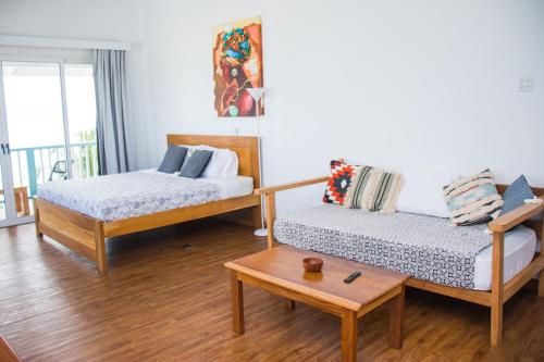 a living room with two beds and a table at Chango's Apartments in Bocas del Toro