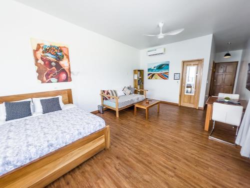a bedroom with a bed and a living room at Chango's Apartments in Bocas del Toro