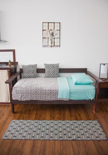 a bedroom with a bed and a rug on a wooden floor at Chango's Apartments in Bocas del Toro