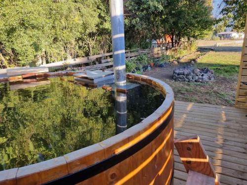 a pond with a pole in the middle of a wooden deck at Cabañas Antü Küyen Melipeuco in Melipeuco