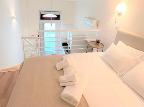 een wit bed met witte kussens in een kamer bij ESTÚDIO 81 junto à Sinagoga in Tomar