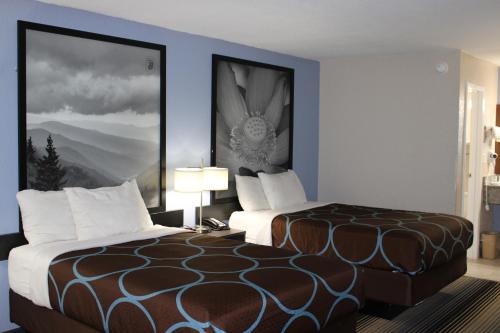 a hotel room with two beds and a picture on the wall at Super 8 by Wyndham Morganton in Morganton