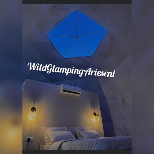 a room with a bed with a blue umbrella on the wall at WildGlampingArieseni in Arieşeni