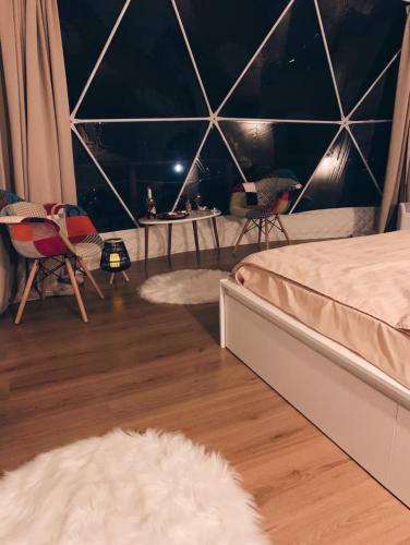 a bedroom with two beds and a table and chairs at WildGlampingArieseni in Arieşeni