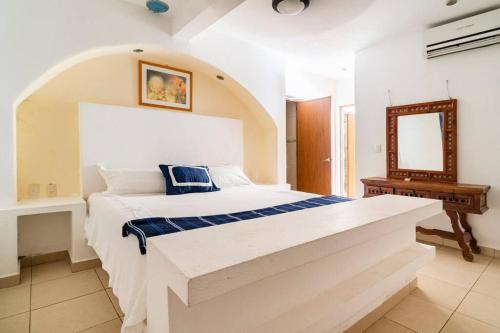 a bedroom with a large bed and a mirror at Villa Palmitas acogedor departamento nivel piscina gigante jardines in Acapulco