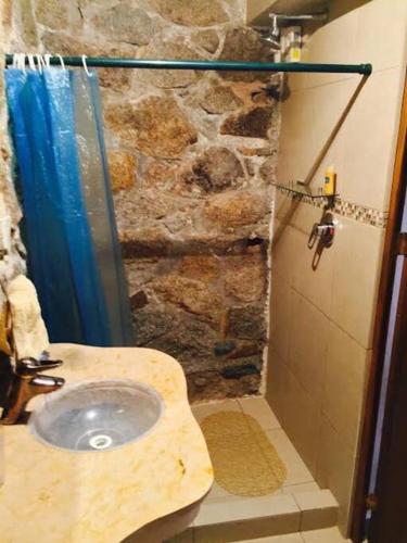 a stone bathroom with a sink and a shower at Villa Palmitas acogedor departamento nivel piscina gigante jardines in Acapulco