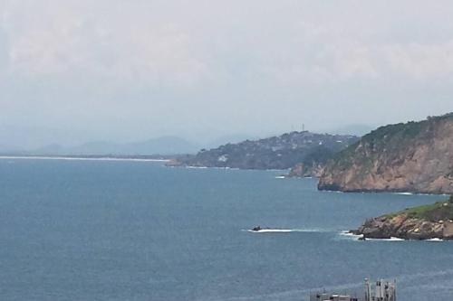 a large body of water with a boat in it at Villa Palmitas acogedor departamento nivel piscina gigante jardines in Acapulco