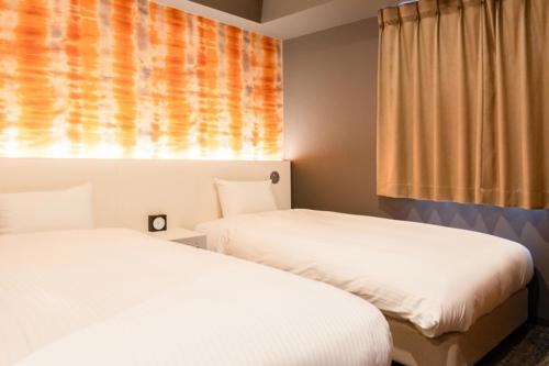 a room with two beds and a window withacers at Cinnamonhotel2 in Osaka