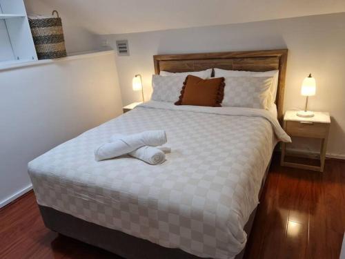 a bedroom with a large white bed with two pillows at Private & Cosy Two Storey Guest House in Guildford