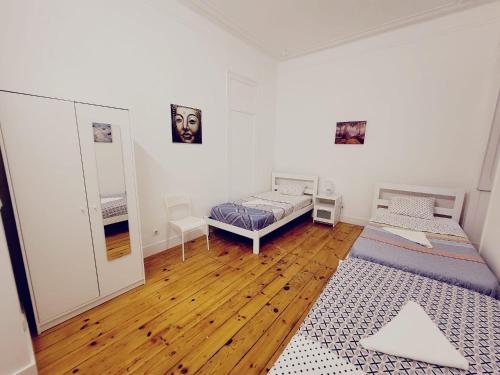 1 dormitorio con 2 camas y suelo de madera en Lisbon Gambori Hostel en Lisboa