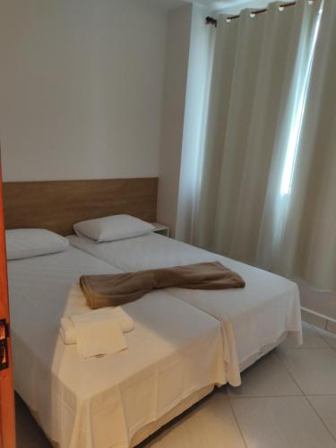 um quarto de hotel com duas camas com lençóis brancos em Condomínio Barretos Thermas Park em Barretos