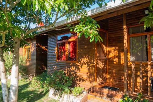 a wooden house with a window and a staircase at Cabañas Barú Dota in Santa María