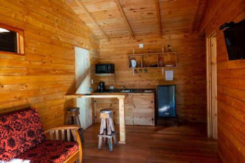 Cabaña de madera con cocina y sofá en Cabañas Barú Dota, en Santa María