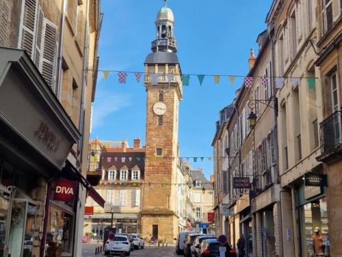 a clock tower in the middle of a street with buildings at Maison rénovée avec jardin clos, proche du centre historique, idéale pour famille ou télétravail - FR-1-489-439 in Moulins