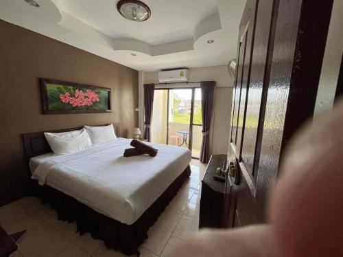 a hotel room with a bed with a teddy bear on it at the links hotel in Pattaya