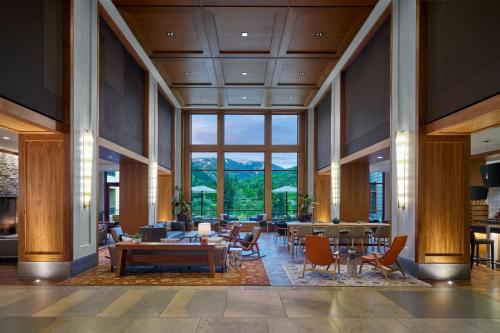 a lobby with tables and chairs and a large window at The Westin Riverfront Mountain Villas, Beaver Creek Mountain in Avon