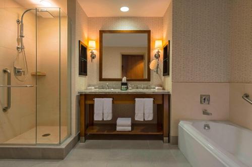 a bathroom with a sink and a tub and a mirror at The Westin Riverfront Resort & Spa, Avon, Vail Valley in Avon